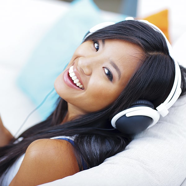 Smiling girl with dark hair in her headphones 