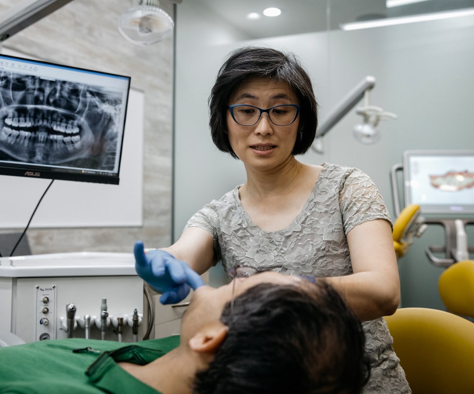 Doctor Lai checks the patient's teeth