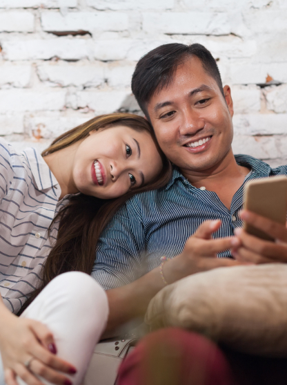 Smiling couple choosing something in smartphone.