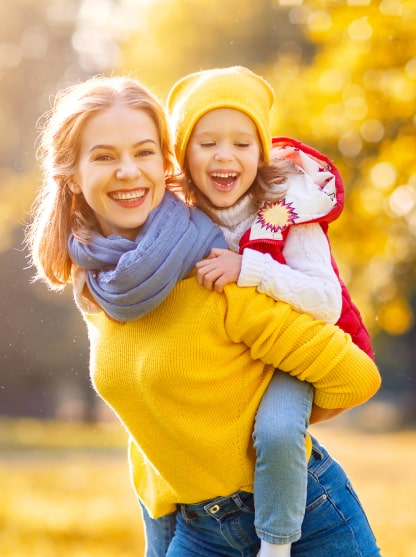 Mother with daughter smiling in autumn park